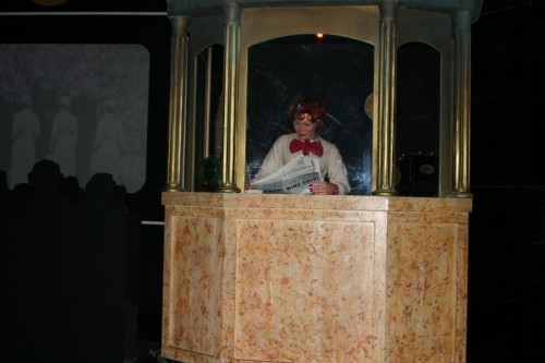 Theater Ticket Taker reading a newspaper in Spaceship Earth.