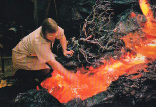 A technician dips his hand into the lava from the Universe of Energy volcano